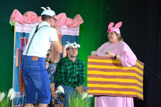 Fragment przedstawienia. Na scenie 3 aktorów, 2 osoby w przebraniach kóz, jedna w przebraniu świnki.