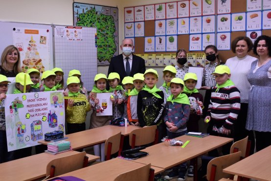 Zdjęcie grupowe nagrodzonej klasy Ib z SP nr 10 w Zgierzu. Do zdjęcia dzieci założyły odblaskowe chusty i czapki, przekazane im w ramach nagrody przez Starostę Zgierskiego Bogdana Jarotę. 